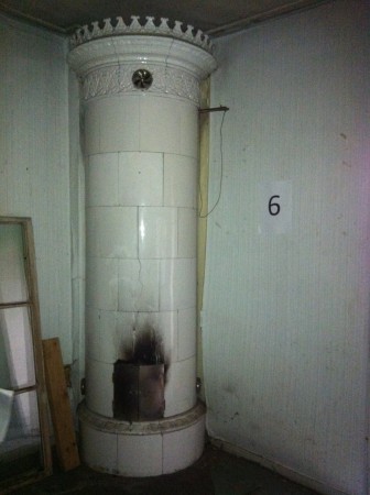 Vit rund ugn med ståtlig krona. Det svarta ovan luckan är bara sot som tvättas bort. H 2590 Diam 760